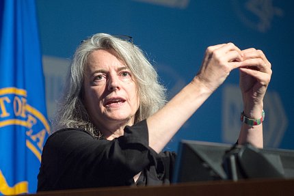 Kieffer gestures from podium during her lecture.