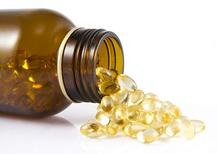 A medicine bottle lies on its side with pills spilling on the table