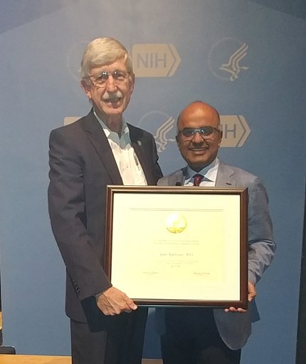 Dr. Kathiresan accepts plaque from Dr. Collins
