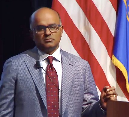 Dr. Kathiresan speaks at podium