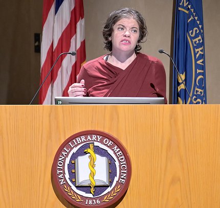 Posner speaks from NLM podium.