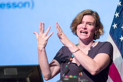 Mazzucato gestures with both hands from podium.