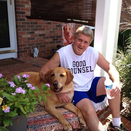 Moore sits on a stoop with his dog
