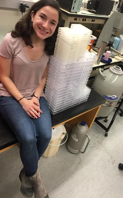 A smiling Margolis poses next to lab equipment.
