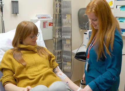 A patient in bed being seen by nurse