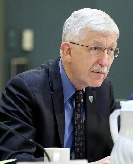 Collins seated at conference table.