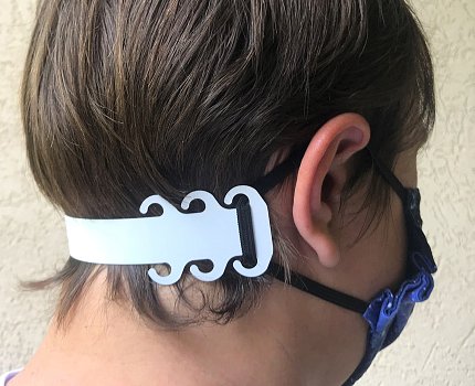 Back of a head wearing the device that extends the straps of a face mask