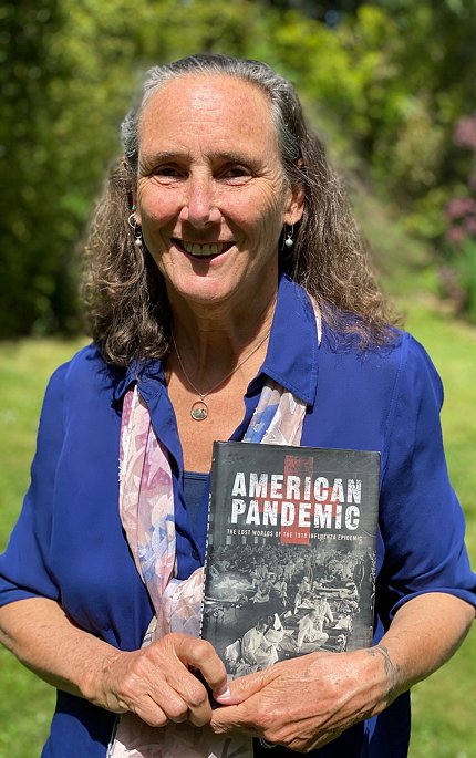 Dr. Bristow stands outside holding her book, titled, American Pandemic