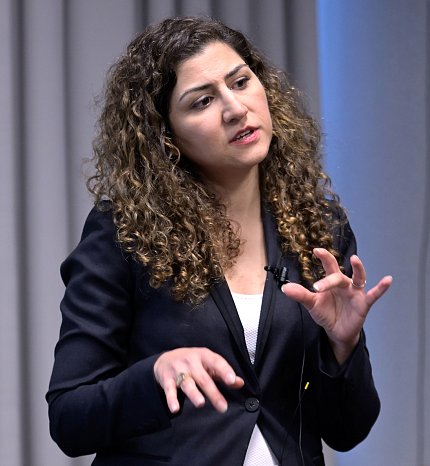 Shanechi extends her hands as she explains her work, in Neuroscience Center conference room.
