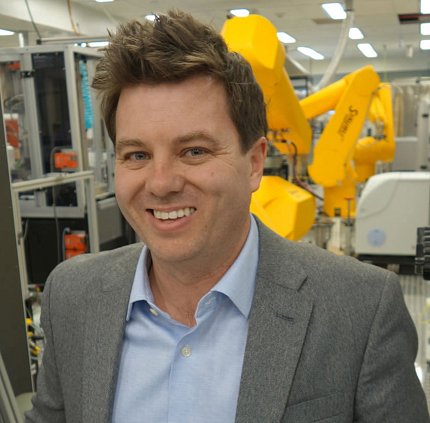A smiling Dr. Matthew Hall standing in his lab