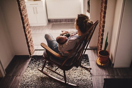 Woman and baby in rocking chair, facing window