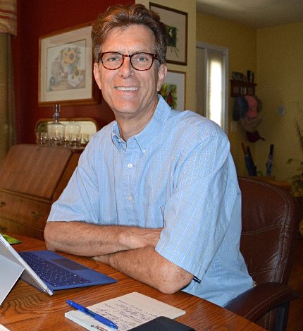 Smiling, Jordan is seated at a table