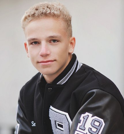 Luke poses in a black leather jacket.