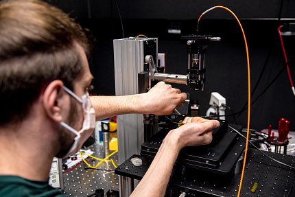 Close-up of Fineberg in mask, with his hands adjusting parts of a machine