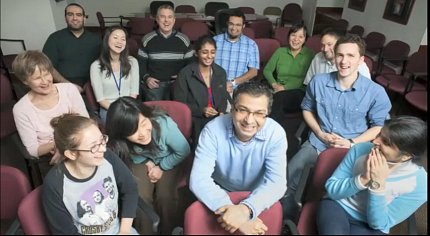 Bharti and his lab share a laugh with each other while sitting in a conference room.