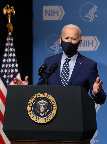 Behind presidential seal, Biden speaks from podium.