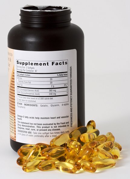 Yellow capsules lay beside a bottle, showing the ingredient label