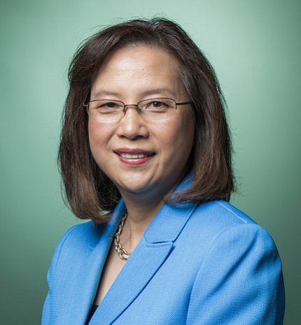 Head shot of a smiling Grace Ma, wearing a light blue suit