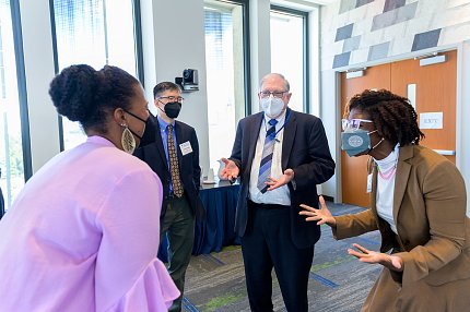 Elam, Chiang, Tabak and Nwanyanwu chat informally. All are wearing masks.