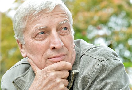 An older man stares into the distances