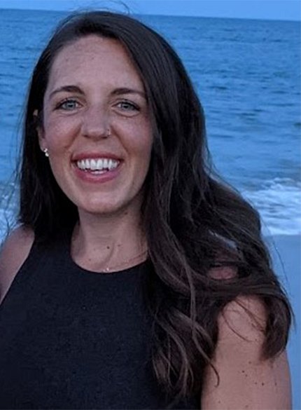 A smiling Shannon Wooldridge with the ocean behind her