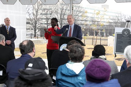 Van Hollen speaks from the podium, with sign language interpreter beside him.