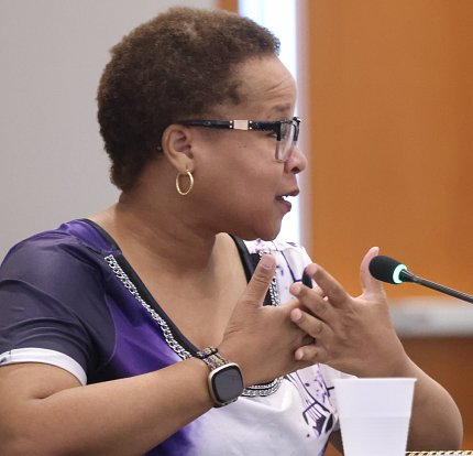 Walther, hands clasped over heart in thanks, speaks into mic.