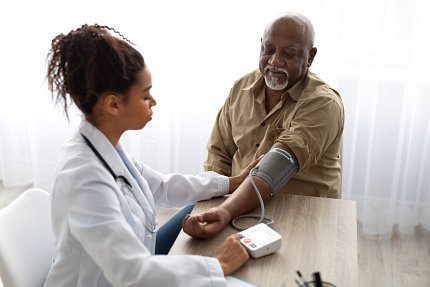 A health professional checks a man's blood pressure