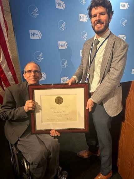 Cooper accepts certificate from Bulea