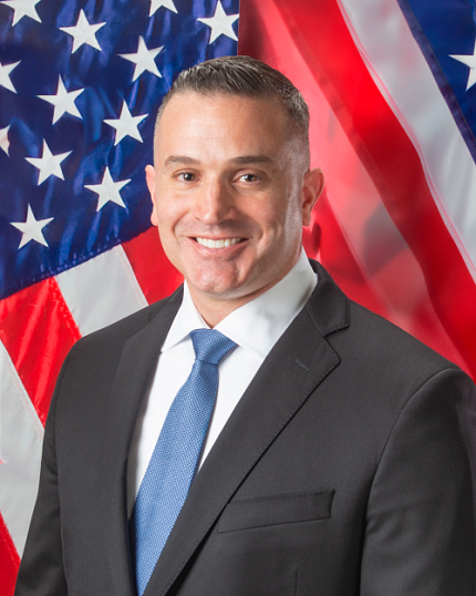 Pasiakos smiling with American flag in background