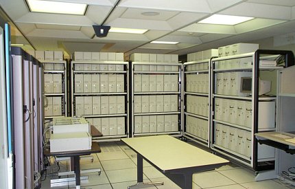 dozens beige boxes stacked on metal shelving units