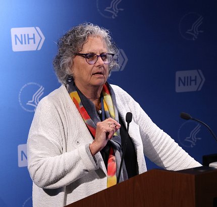 Sandler talks into microphone at podium in Lipsett Amphitheater