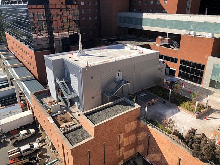 Aerial image of a multistory brick building. The modular terrace facility is a gray building positioned on an outdoor terrace.