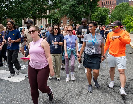 A group of people congregate to walk, colorful clothes