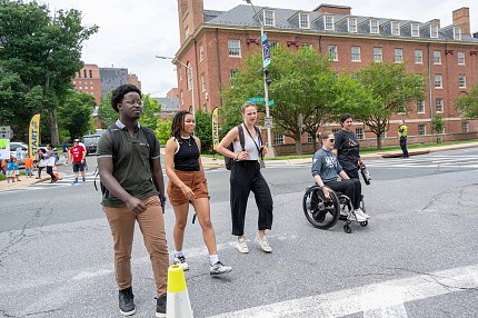 Group of people standing and one person in a wheelchair outside Bldg. 1