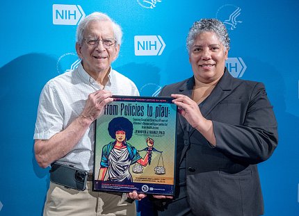 Man and woman hold framed poster