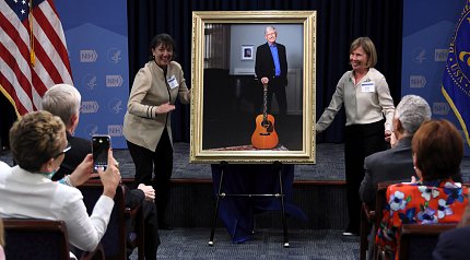 Bertagnolli and Baker smile, pointing to the portrait.