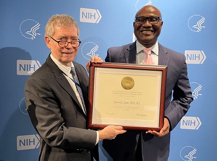 Egede accepts a large plaque from Murray