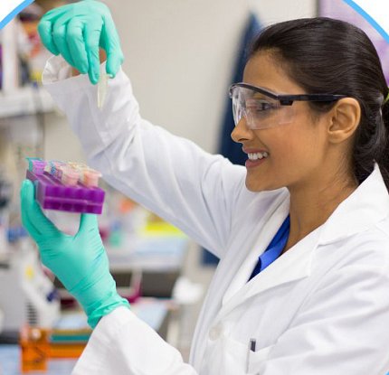 A woman in a lab coat looks at test tube
