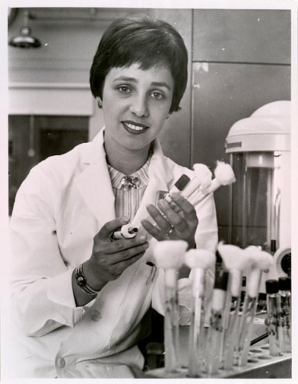 Black-and-white photo of Singer holding pipettes in a lab.