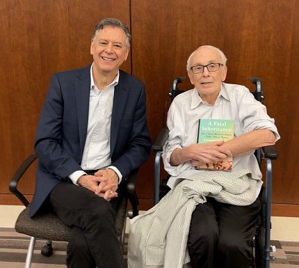 Ingrassia and Fraumeni seated together, with the book Fatal Inheritance on Fraumeni's lap