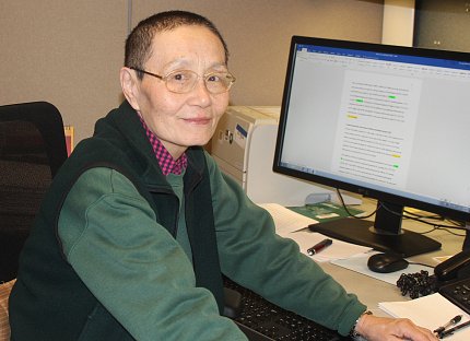 Hu sits at her computer.