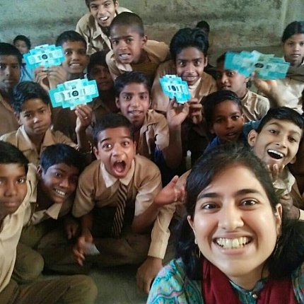 Children hold up their Foldscopes 