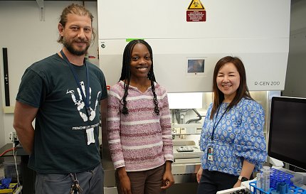 Park (right) with two colleagues next to the 3D bioprinter in the lab