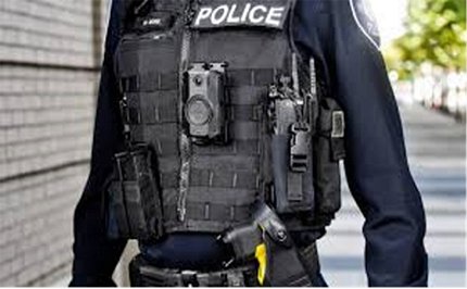 An officer in uniform with a camera clipped to his vest