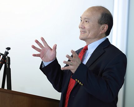 Liang speaks at the podium