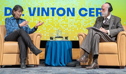 Bertagnolli and Cerf, seated on stage, gesture toward each other