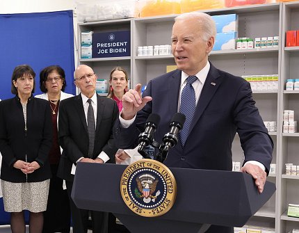 Closer view of Biden at podium. Also in frame is Bertagnolli and three other people.