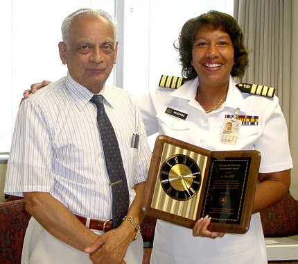 Ram accepts a plaque from Mishoe.