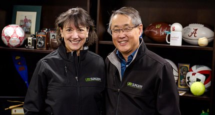 Bertagnolli and Chen pose together, smiling in front of book shelf